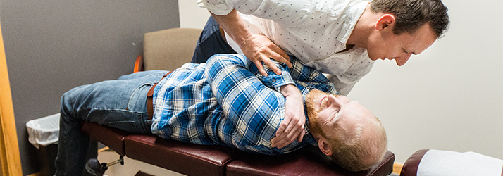 Chiropractor Mt. Pleasant WI Andrew Johansen Adjusting Patients Shoulder