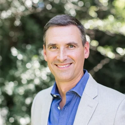 Brian Trautman smiling while standing outside.